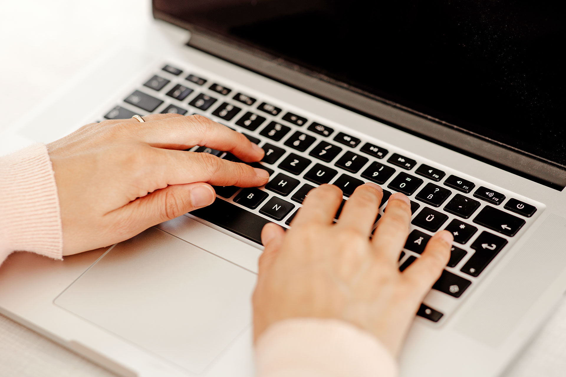 Hände über einer Laptop-Tastatur